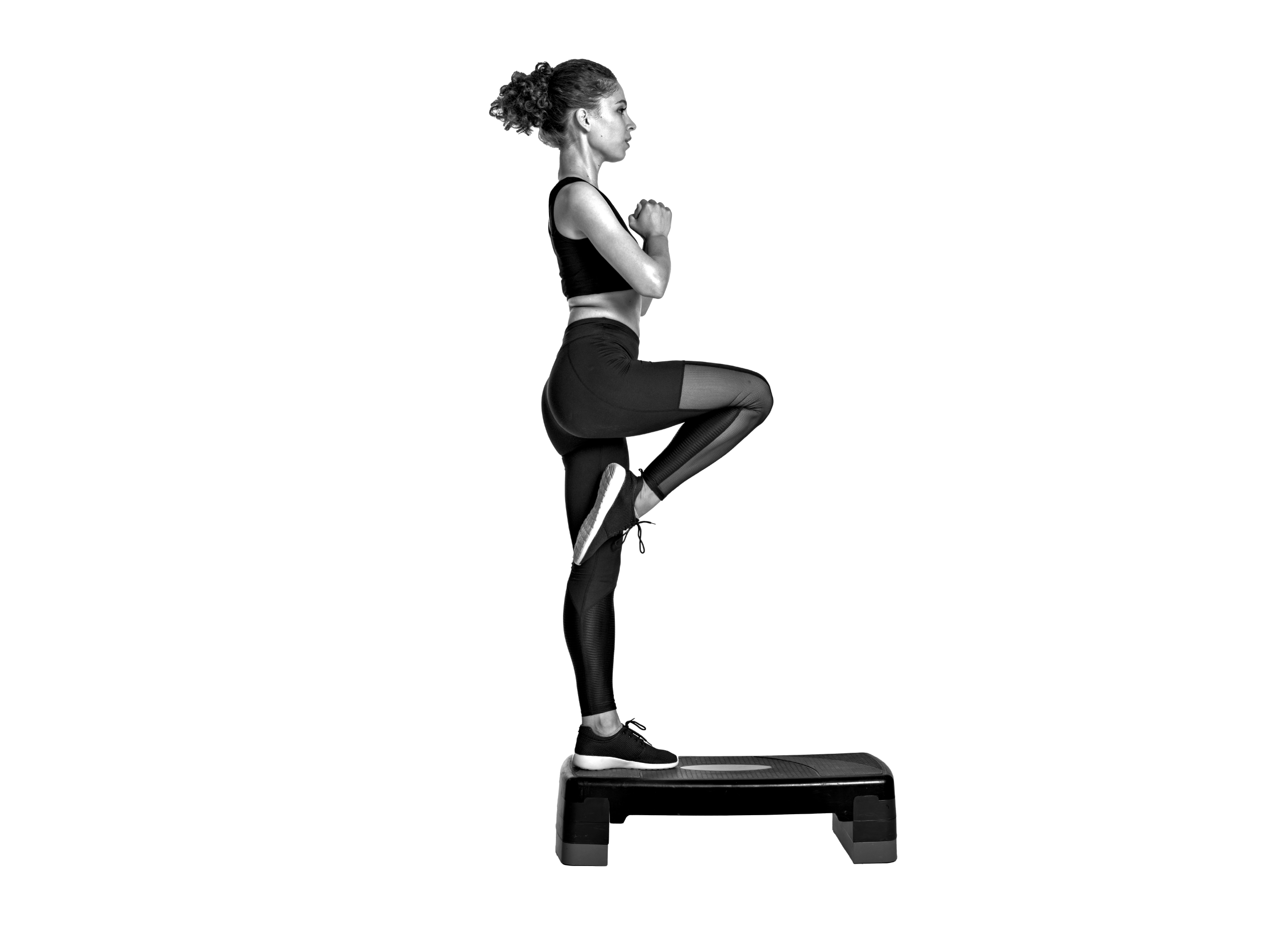 Mujer realizando un ejercicio de cardio step de alta intensidad sobre una plataforma en el gimnasio Duplex de Andorra la Vella.