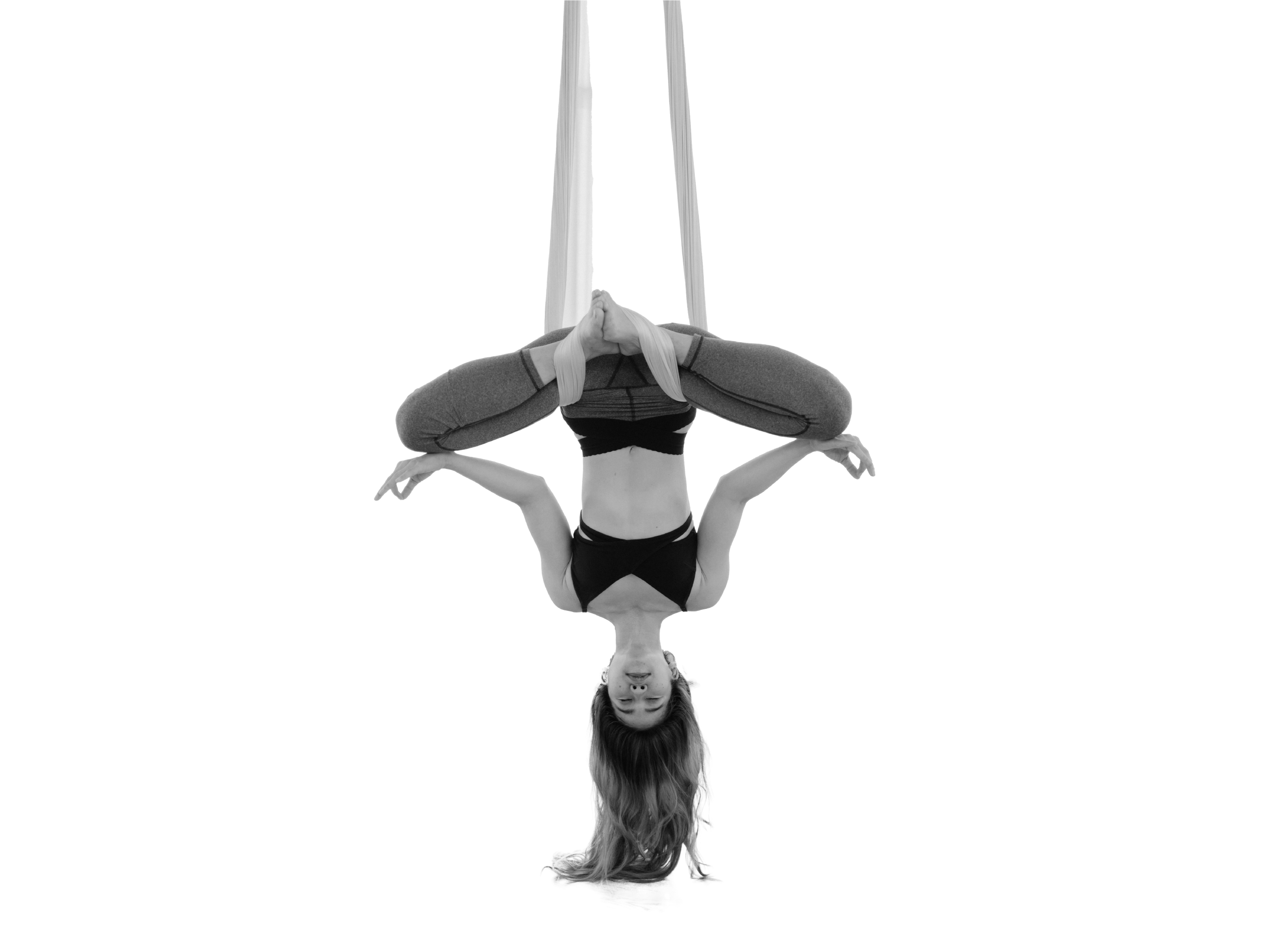 Mujer practicando una postura en suspensión con columpio durante una clase de aero yoga en el gimnasio Duplex de Andorra la Vella.